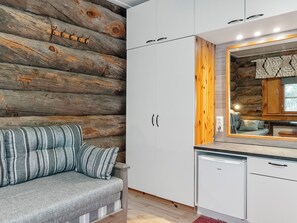 A modern kitchen with white cabinets, a built-in oven, and a wooden wall.
