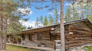 A rustic log cabin with a porch, surrounded by trees. - Raahenmaja by Interhome (Inari)