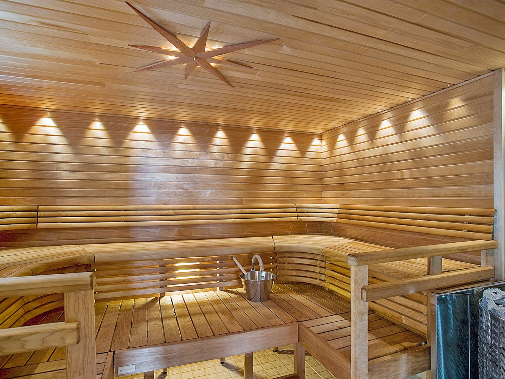 A sauna with wooden benches and a star-shaped ceiling light.