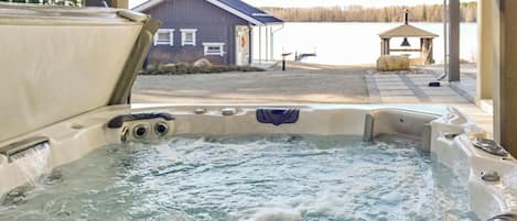A hot tub with a view of a building and a lake.