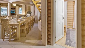 A wooden interior with a dining area, a staircase, and a door leading to another room. - Riemurahi by Interhome (Pertunmaa)