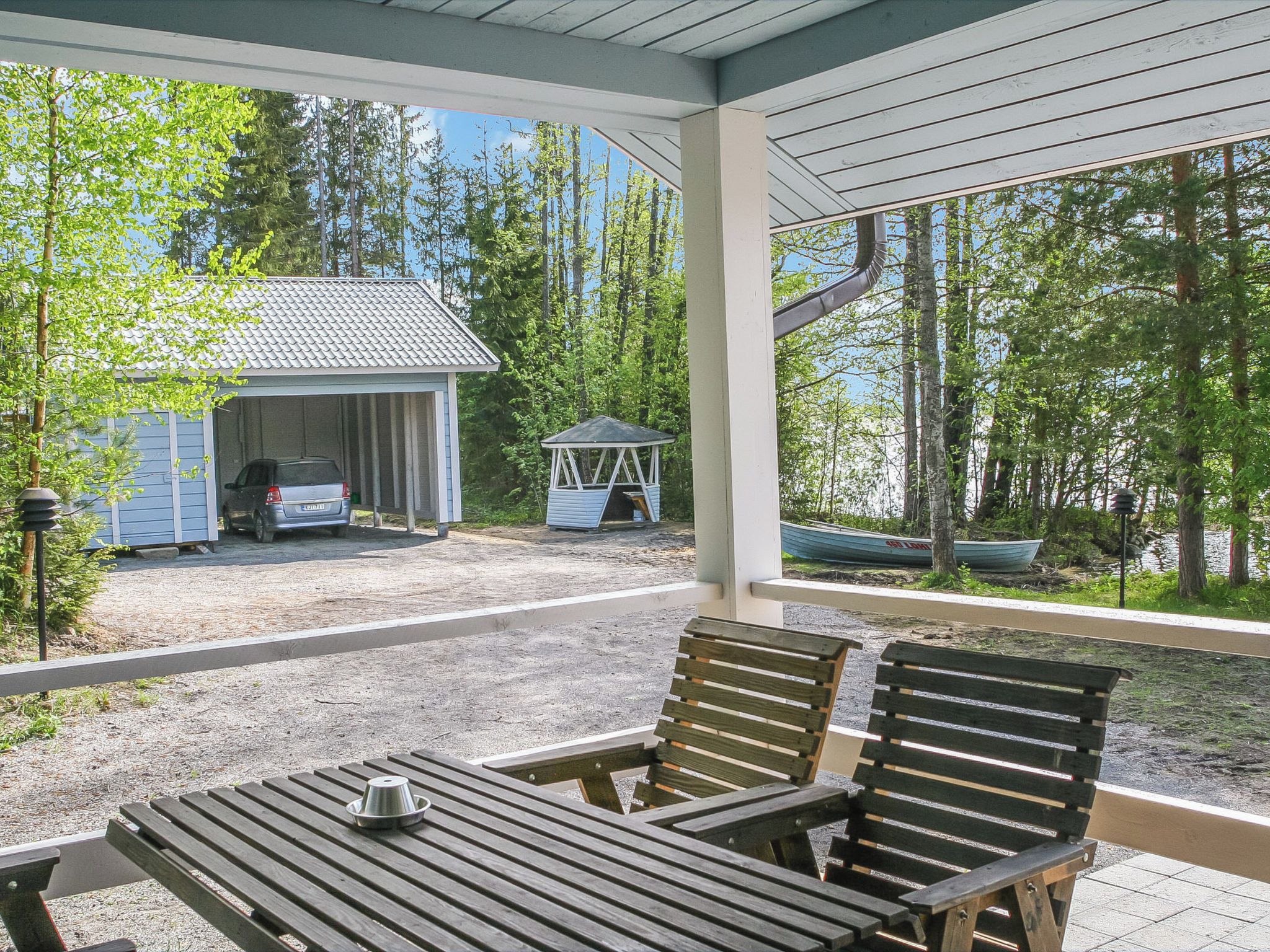 A covered outdoor area with a table and chairs, a small shed, and a gazebo.