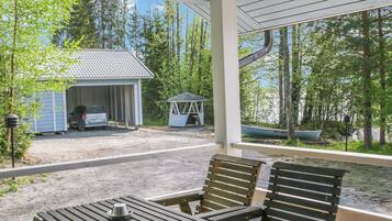 A covered outdoor area with a table and chairs, a small shed, and a gazebo.