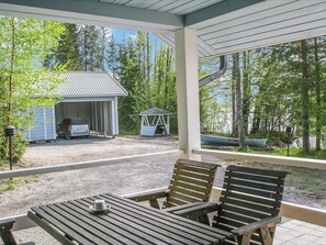 A covered outdoor area with a table and chairs, a small shed, and a gazebo.