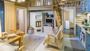 A cozy cabin interior with a dining area, a fireplace, a television, and a kitchen. - Onnimökki by Interhome (Pertunmaa)
