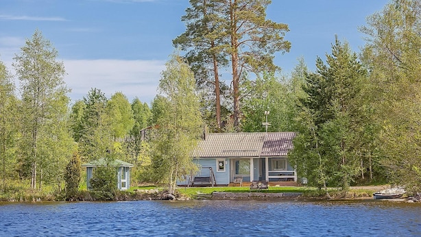 A cabin by a lake surrounded by trees. - Onnimökki by Interhome (Pertunmaa)