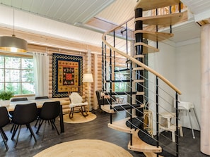A modern interior with a spiral staircase, a dining area, and a large rug. - Villa usva by Interhome (Lieksa)