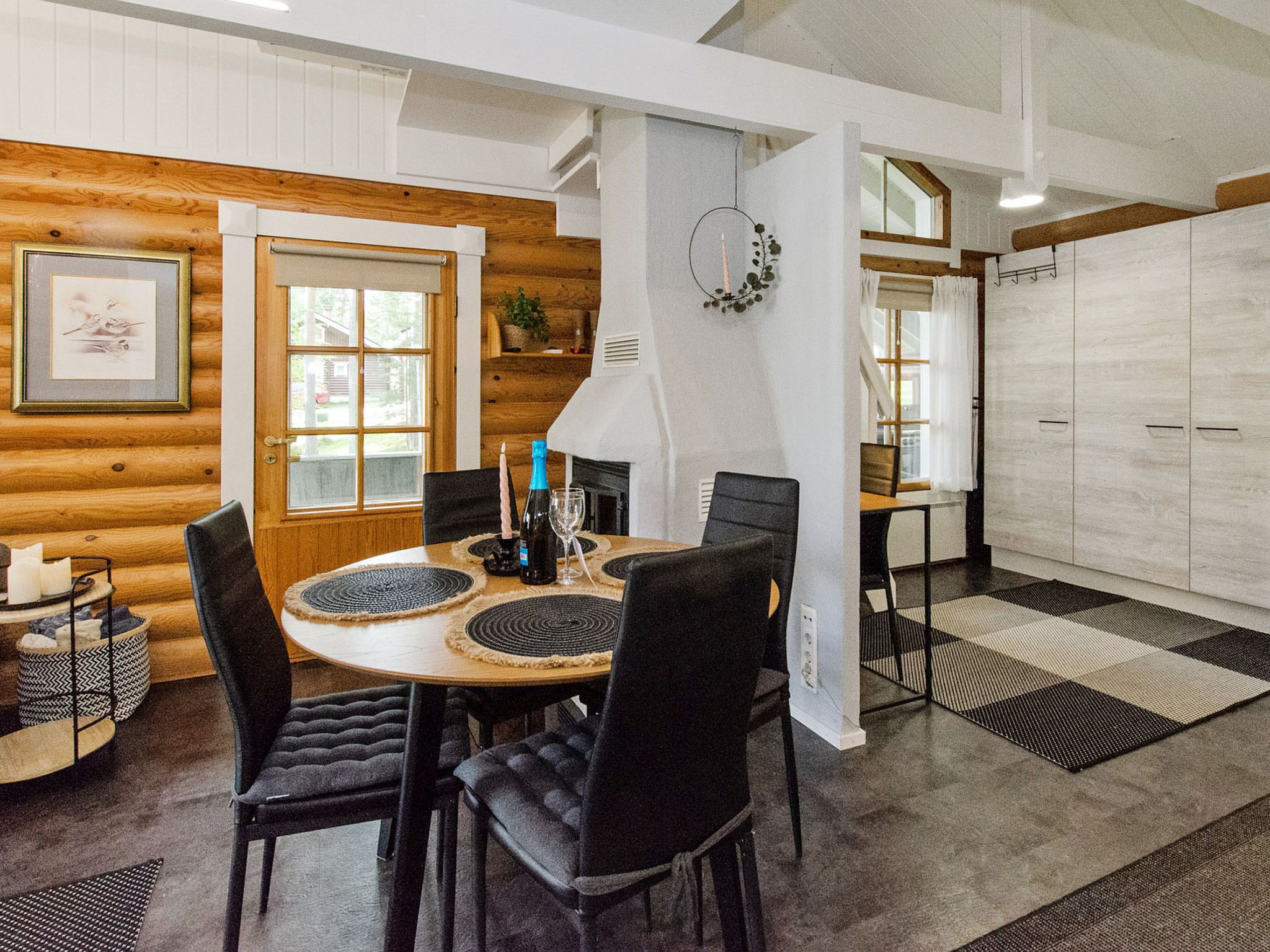 Un comedor acogedor con una mesa de madera, sillas negras y una chimenea.