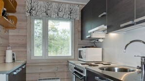 A compact kitchen with a microwave, stove, and sink.