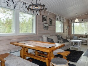 Un salon chaleureux avec une table en bois, des bancs et un canapé.
