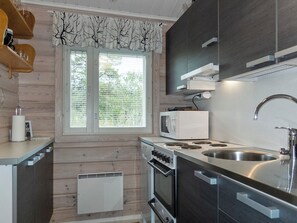 A modern kitchen with a built-in oven, microwave, and stainless steel sink.