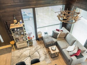 A modern living room with a grey sofa, a coffee table, and a decorative chandelier.