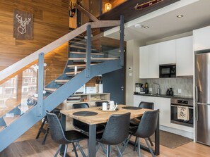 A modern kitchen with a built-in oven, a microwave, and a stainless steel refrigerator.
