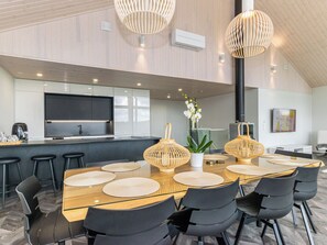 A modern kitchen with a central island, bar stools, and pendant lighting.