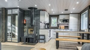 A modern kitchen with a central island, a built-in stove, and a dining area with benches.