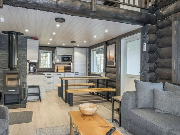 A modern log cabin interior with a kitchen, dining area, and seating. - Vaaranpää by Interhome (Rovaniemi)