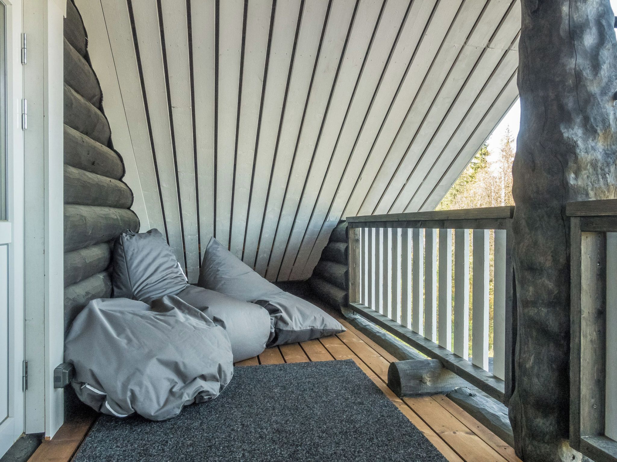 Ein gemütlicher Sitzbereich mit schrägverdeckter Decke und einer Holzterrasse.