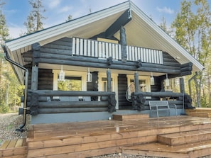 A log cabin with a balcony, wooden deck, and a view of the surrounding forest. - Vaaranpää by Interhome (Rovaniemi)