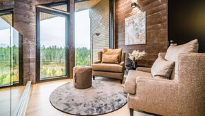 Un salon moderne avec une grande fenêtre, un tapis rond et un canapé.