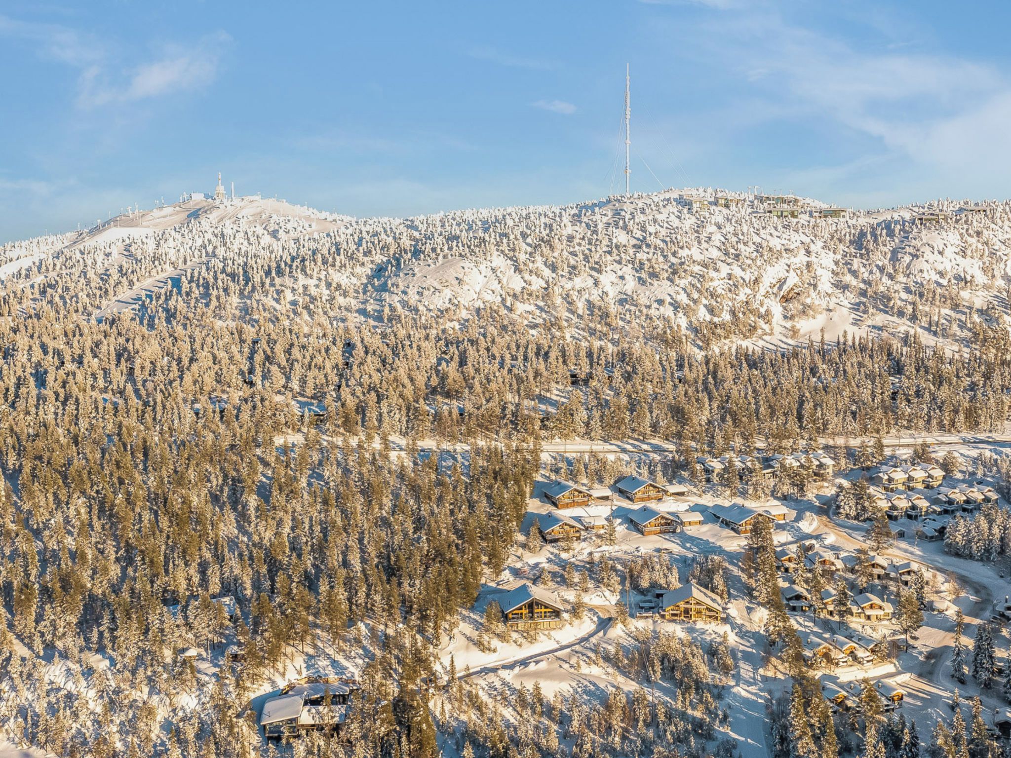 A snow-covered mountainous area with a ski resort and cabins.