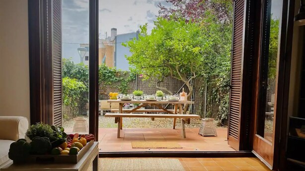 Een moderne woonkamer met een grote schuifdeur die uitkomt op een terras.