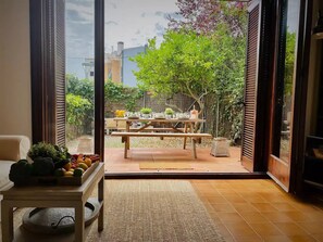 Un salon moderne doté d’une grande porte-fenêtre coulissante donnant sur un espace patio extérieur.