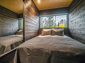 A bedroom with a large window, wooden walls, and a bed with pillows. - Villa voimapolku 9 a 2 by Interhome (Kuusamo)