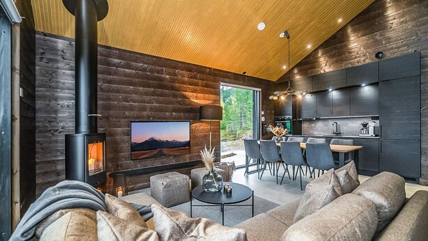 Ein modernes Interieur mit Kamin aus Stein, einem großen Fernseher und einem Essbereich.