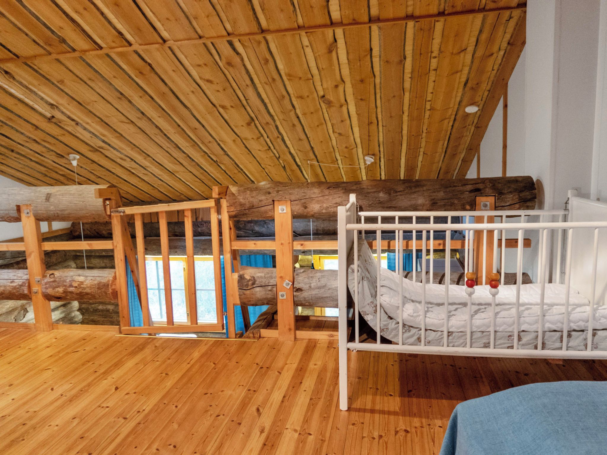A wooden floor, a bunk bed, and a slanted ceiling.