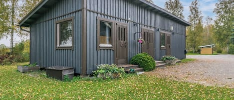 A single-story building with a sloped roof, a front door, and two windows.