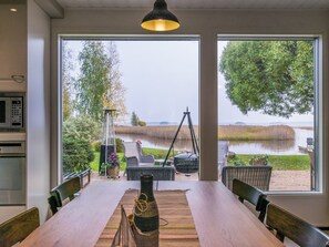 A dining area with a view of a lake and trees. - Kiviniemi by Interhome (Kerimäki)