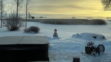 A snowy landscape with a snow-covered car, a lantern, and a birdcage.
