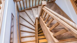 Een houten spiraaltrap met een leuning en een houten leuning aan de zijkant.