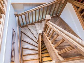 Un escalier en colimaçon avec des rampes et des marches en bois.