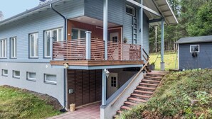 Een tweelaags huis met een balkon, een garage en een kleine schuur in de tuin.