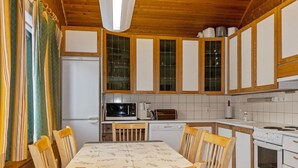 A compact kitchen with wooden cabinets, a microwave, a toaster, and a stove.