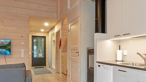 A modern kitchen with white cabinets, a built-in oven, and a black range hood.