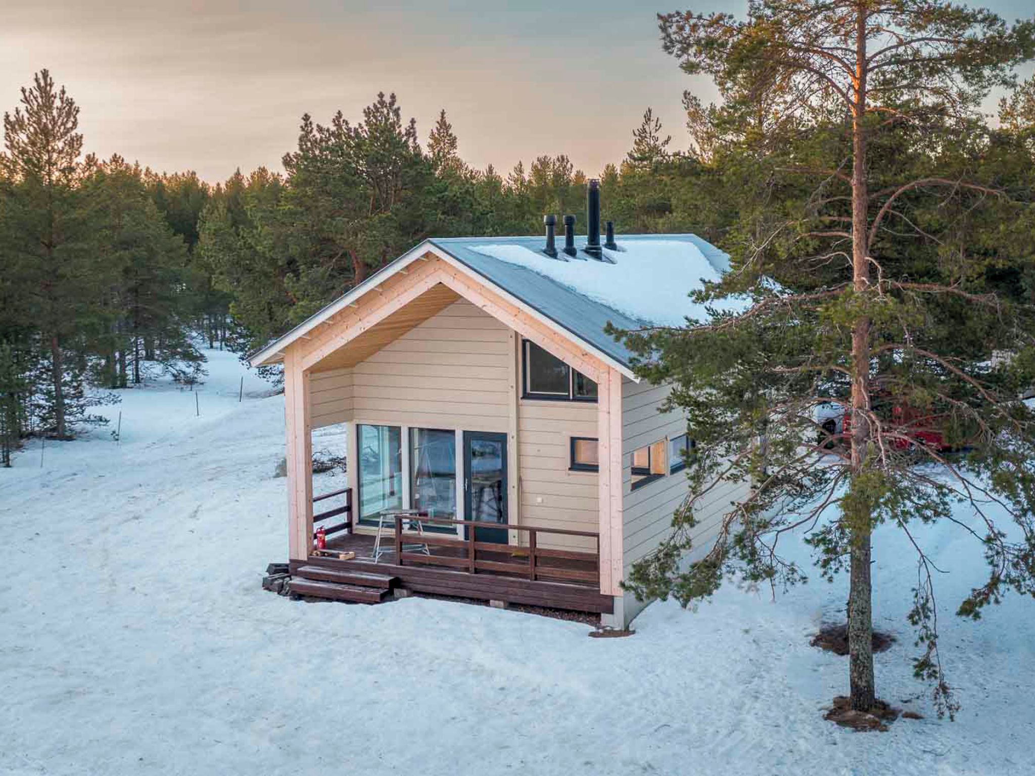 A small cabin with a sloped roof, wooden exterior, and a glass door entrance.