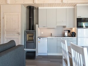 A compact kitchen with a built-in stove, a coffee maker, and a refrigerator.