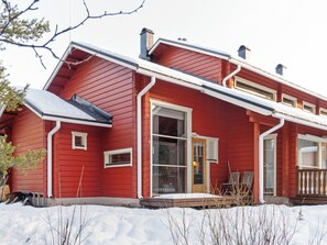 A red house with a large front window, a chimney, and a snow-covered roof. - Aisakello by Interhome (Kittilä)