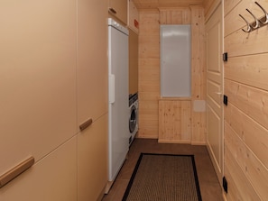 A compact laundry room with a washing machine, a dryer, and a door with a metal hook.