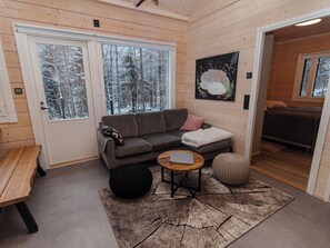 A cozy interior with a grey sofa, a small round table, and a bench. - Mäkitie 4 by Interhome (Kuusamo)