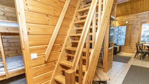Een houten interieur met een spiraaltrap, een bank en een eethoek.