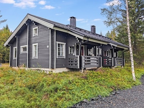 A two-story cabin with a porch, surrounded by natural vegetation. - Ukko 14 by Interhome (Kuusamo)