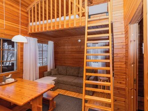 A cozy cabin interior with a loft bed, a dining area, and a seating space. - Ukko 14 by Interhome (Kuusamo)