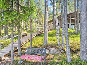 A wooden staircase leading to a building surrounded by trees.