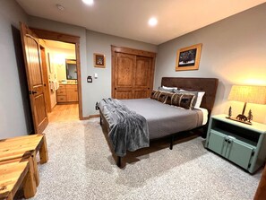 A bedroom with a bed, wooden wardrobe, a nightstand, and a small table. - Walk to Main St. • Near Snowflake Lift • Hot Tubs+Pool (Breckenridge)