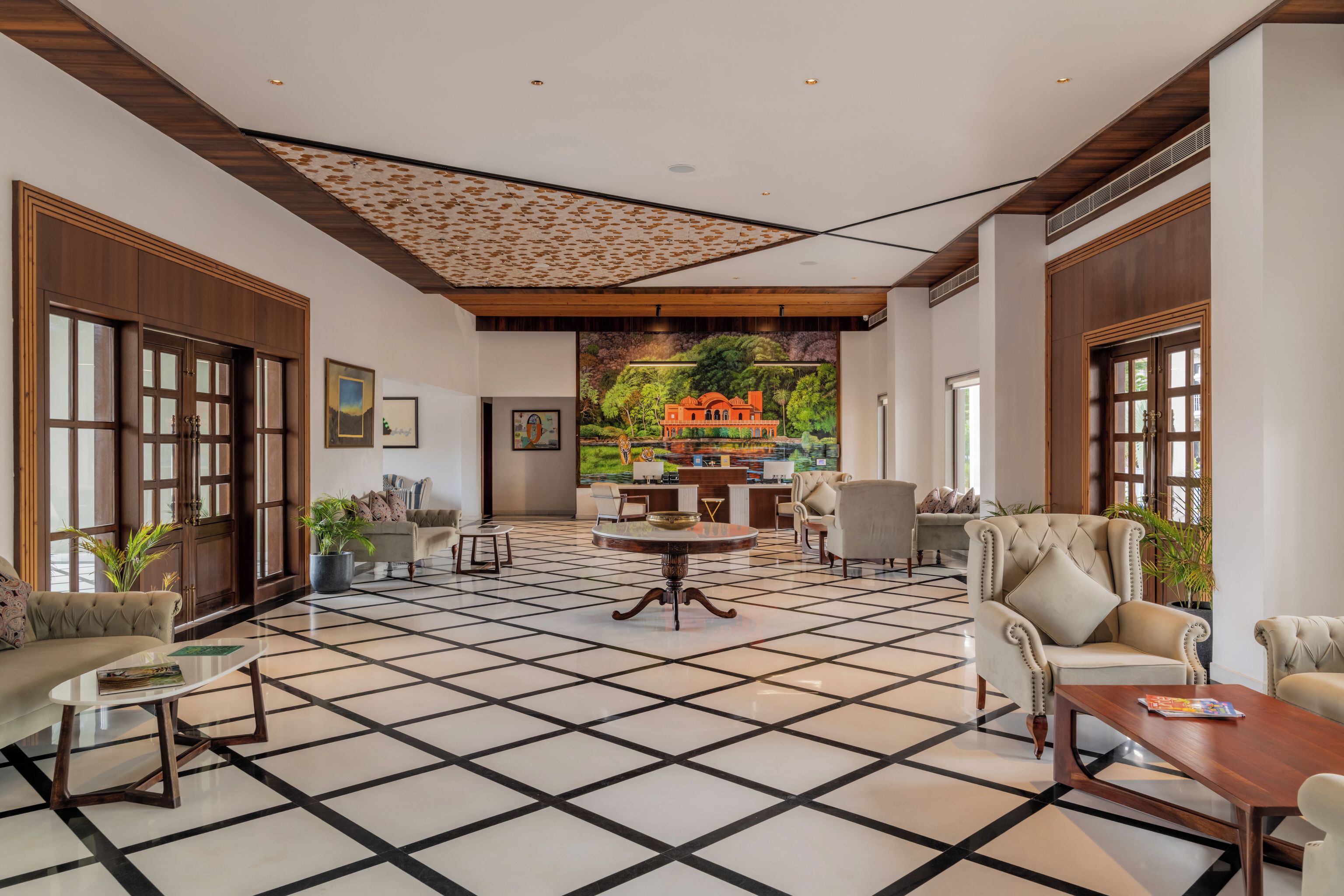 A spacious lobby with a checkered floor, a central round table, and seating arrangements.