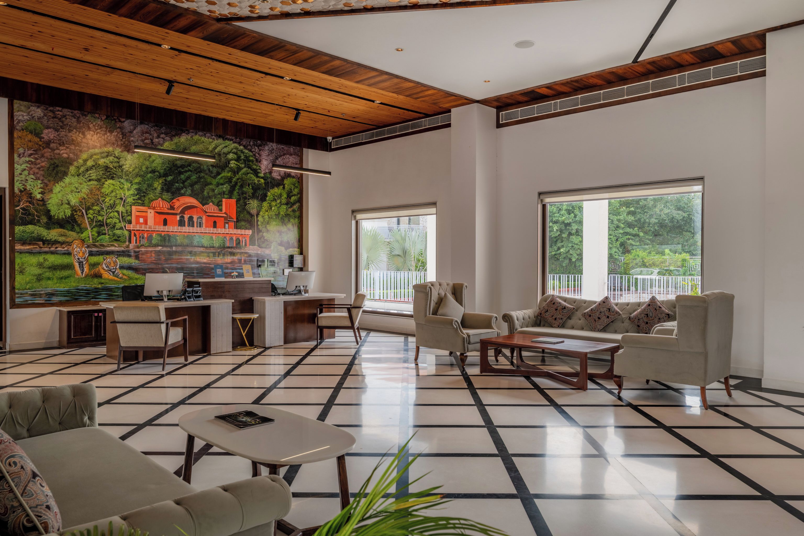 Ampla sala de estar com uma grande pintura, lareira e vista para o verde lá fora.