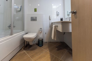 Un baño con inodoro, lavabo, espejo y ducha.